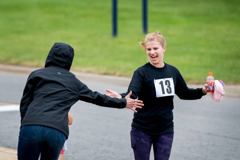 Kristen Evans excitedly high-fiving a colleague during the race